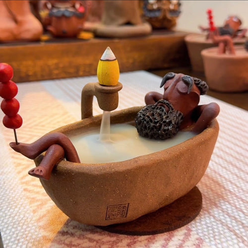Handmade Dharma Bath Backflow Incense Burner with smoke flowing into the bathtub